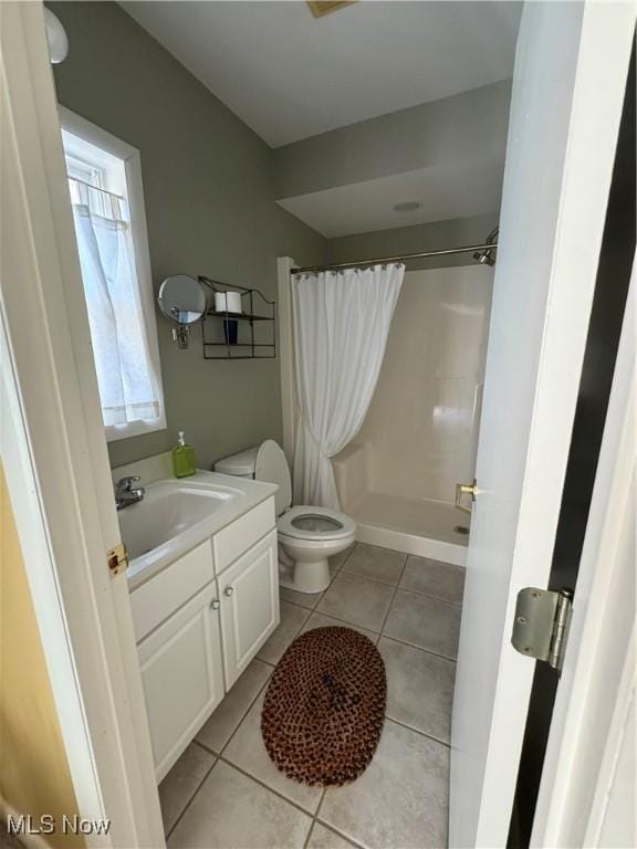 bathroom featuring toilet, a shower with curtain, tile patterned flooring, and vanity