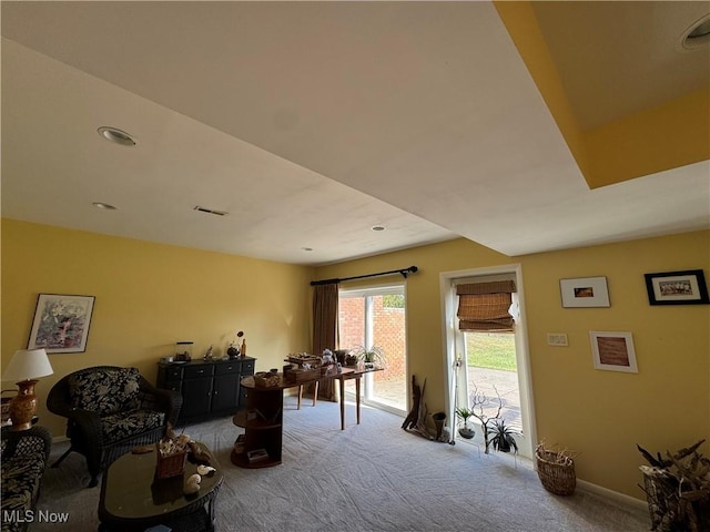 living area featuring carpet, visible vents, and baseboards