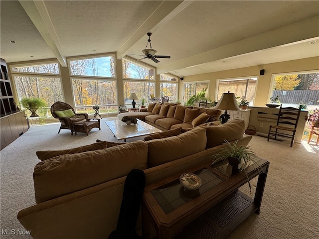 sunroom with vaulted ceiling with beams, plenty of natural light, and a ceiling fan