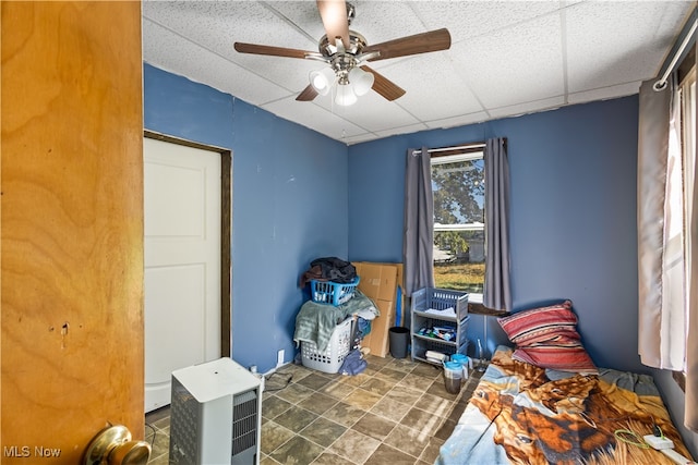 miscellaneous room with ceiling fan and a drop ceiling