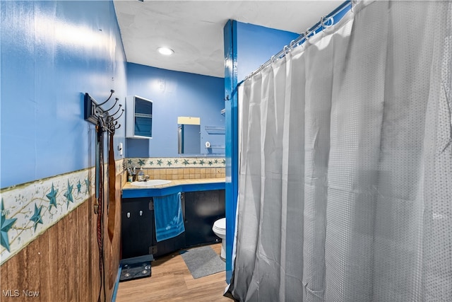 bathroom featuring a shower with curtain, hardwood / wood-style flooring, vanity, and toilet