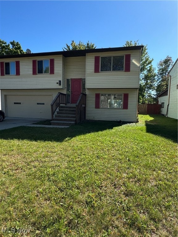 raised ranch with a front yard and a garage