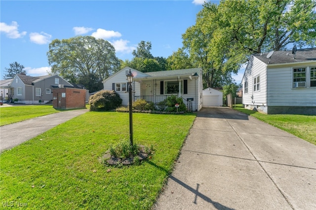 view of front of house with a front lawn, covered porch, an outdoor structure, and a garage