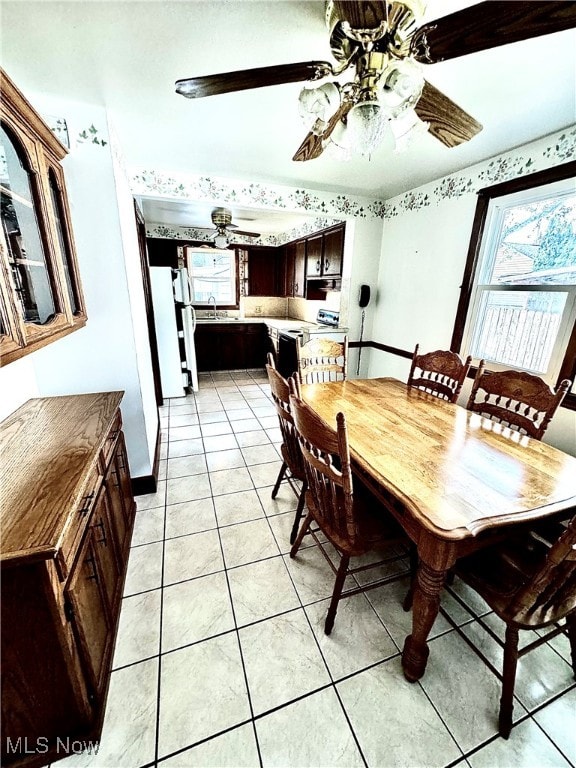 dining room featuring ceiling fan, sink, and light tile patterned floors