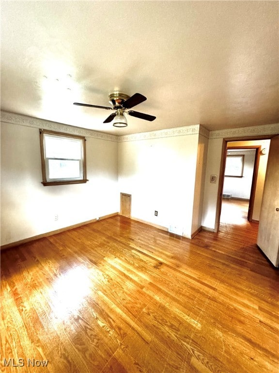 unfurnished room with ceiling fan, a textured ceiling, and hardwood / wood-style flooring