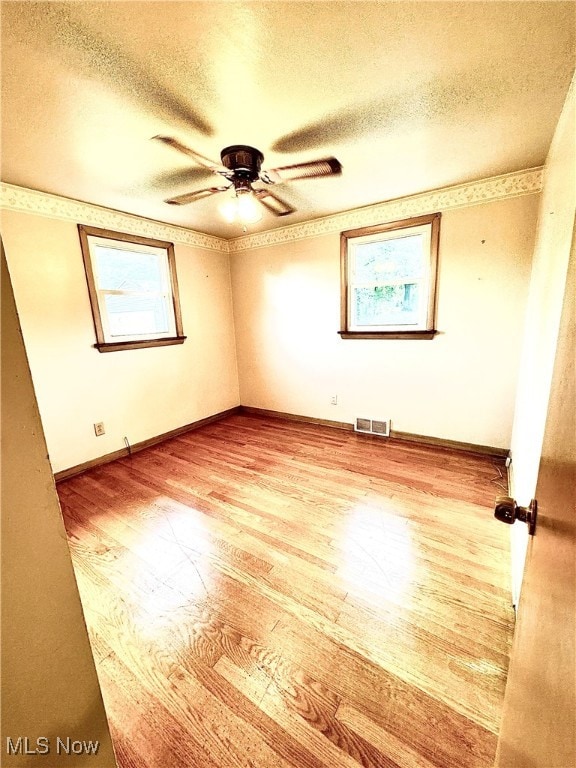 spare room featuring hardwood / wood-style floors, a textured ceiling, and ceiling fan