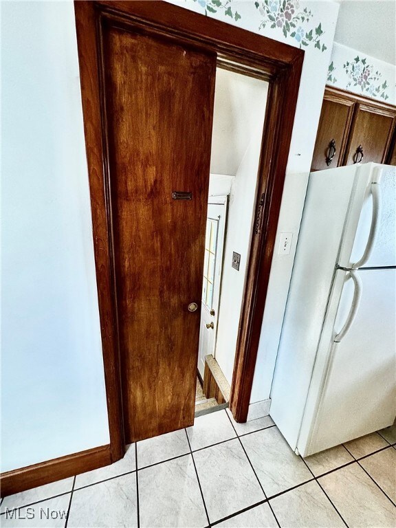 interior space with white fridge and light tile patterned flooring