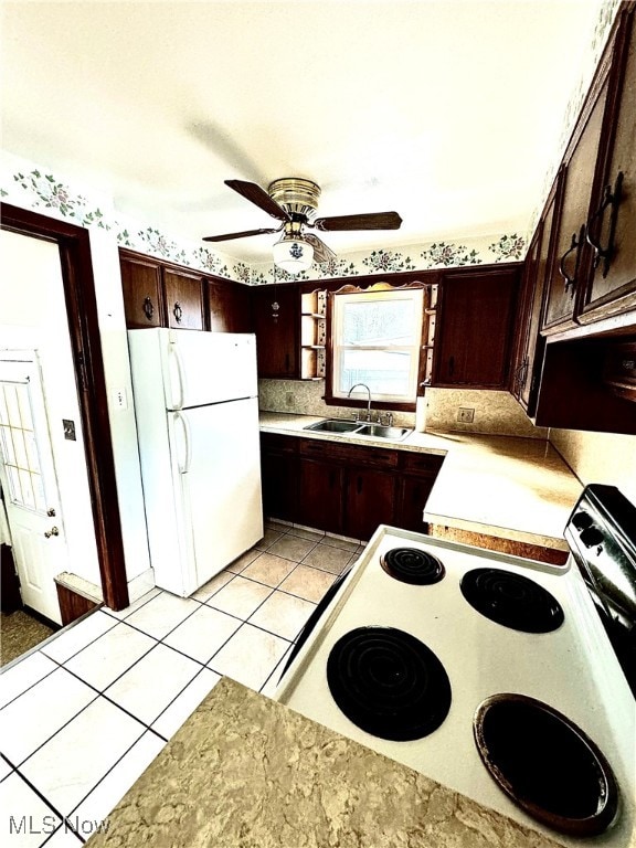 kitchen with white appliances, dark brown cabinetry, ceiling fan, sink, and light tile patterned floors