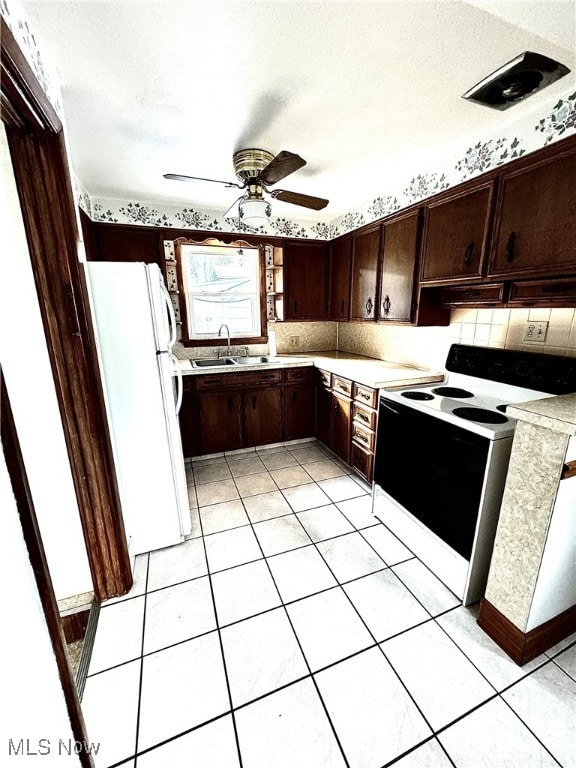 kitchen featuring dark brown cabinetry, ceiling fan, sink, tasteful backsplash, and white appliances