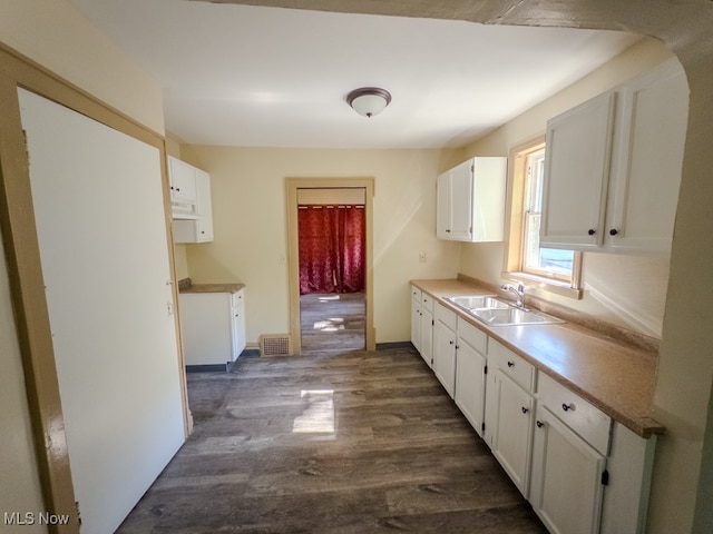 kitchen with white cabinetry, sink, and dark hardwood / wood-style flooring