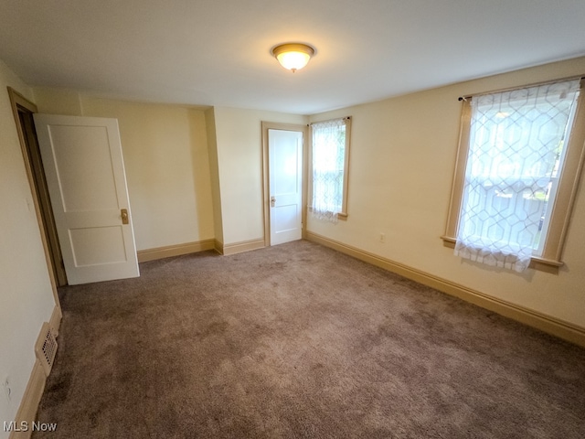 unfurnished room with carpet floors and a healthy amount of sunlight