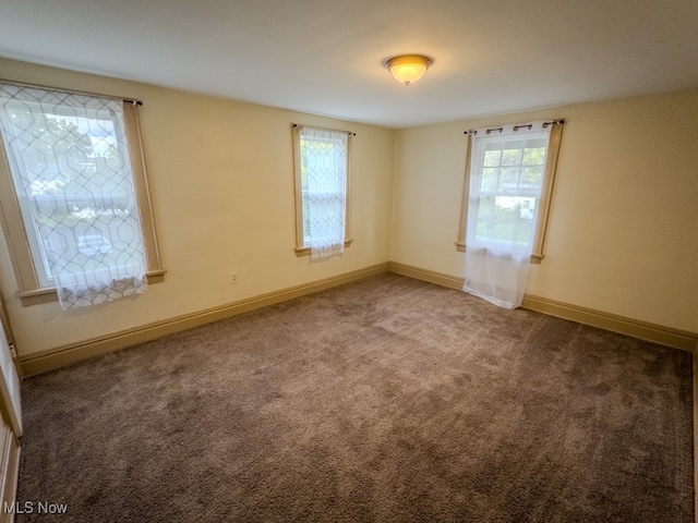 carpeted spare room featuring plenty of natural light