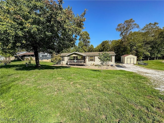 ranch-style home featuring a porch, a front lawn, and a storage shed