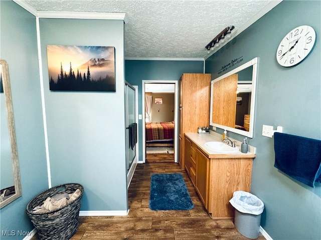 bathroom featuring hardwood / wood-style floors, vanity, an enclosed shower, and a textured ceiling