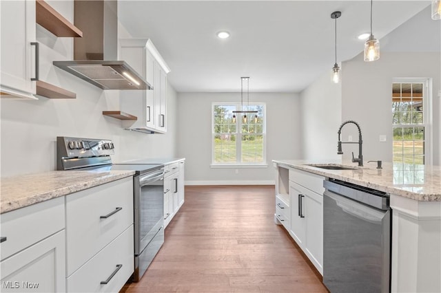 kitchen with white cabinets, wall chimney range hood, sink, and appliances with stainless steel finishes