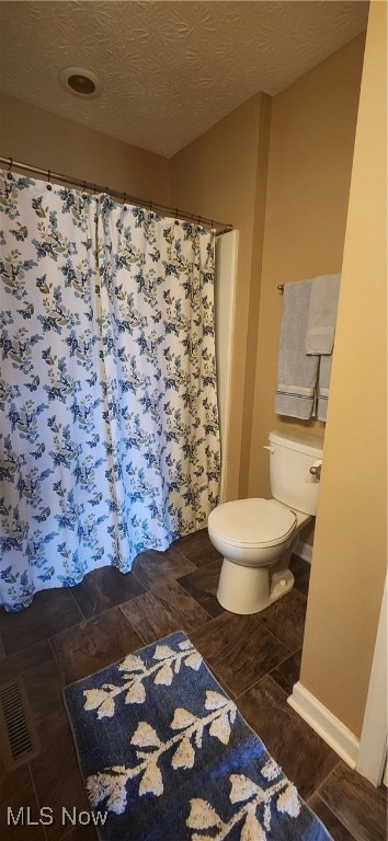 bathroom featuring a textured ceiling and toilet