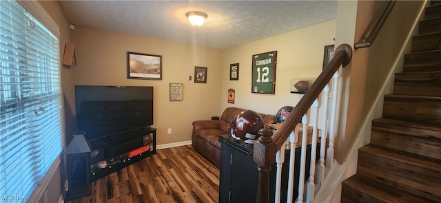 living room with a textured ceiling and dark hardwood / wood-style flooring