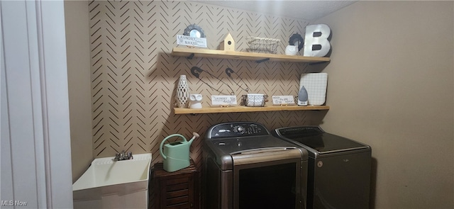 laundry room featuring washing machine and clothes dryer and a textured ceiling