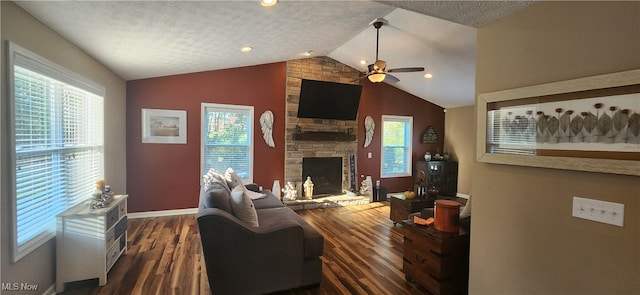 living room with ceiling fan, dark wood-type flooring, vaulted ceiling, a fireplace, and a textured ceiling