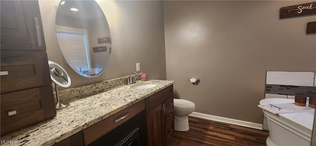 bathroom featuring hardwood / wood-style flooring, vanity, and toilet