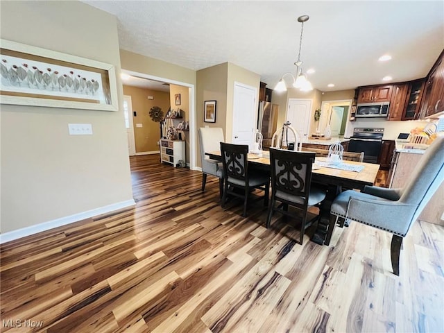 dining room featuring a notable chandelier and light hardwood / wood-style flooring