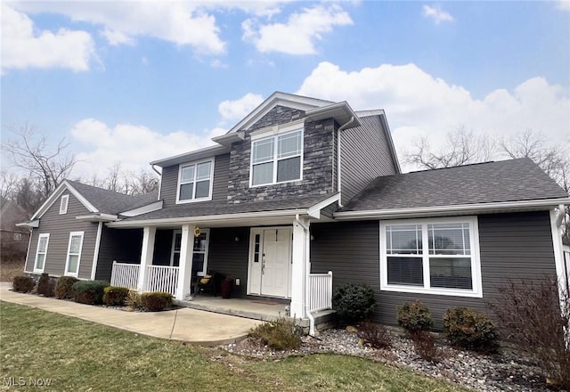 view of front of home with covered porch and a front lawn