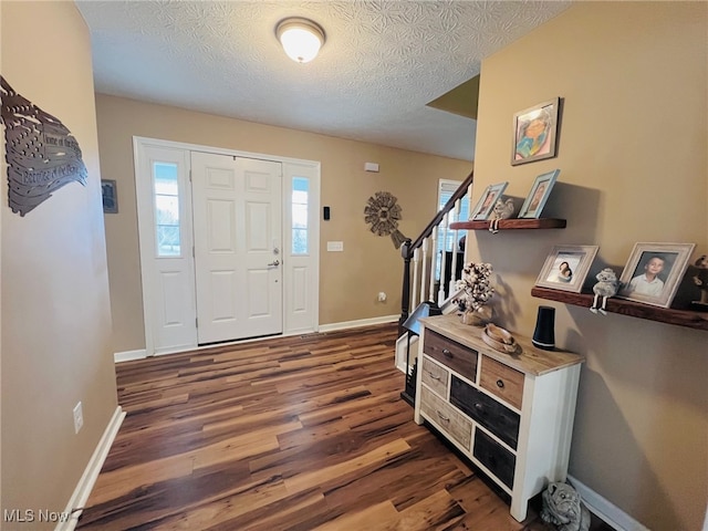 foyer featuring dark hardwood / wood-style floors and a textured ceiling