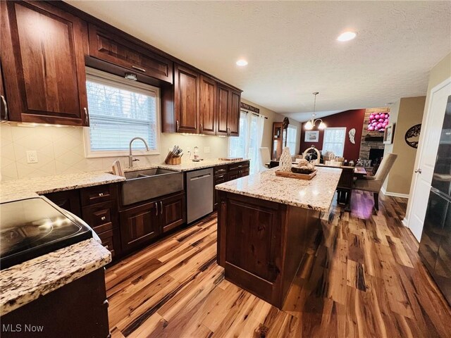 kitchen featuring a kitchen island with sink, decorative light fixtures, dark brown cabinets, and dishwasher