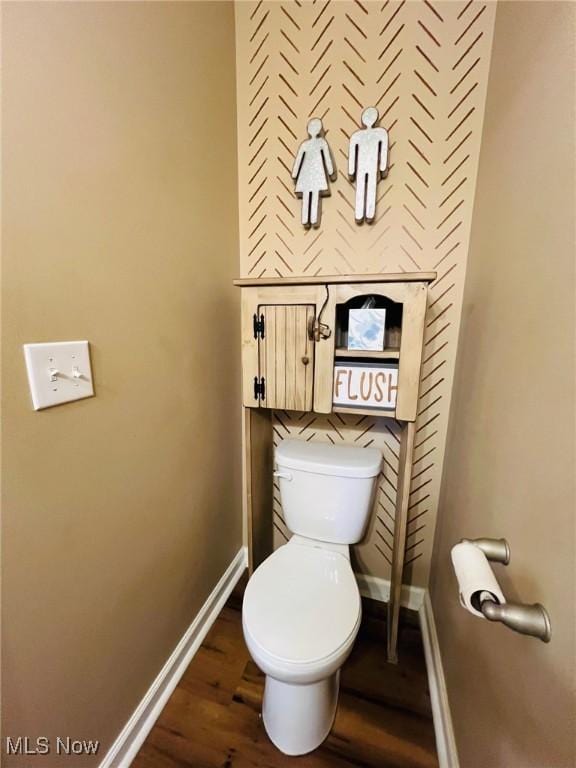 bathroom with hardwood / wood-style flooring and toilet