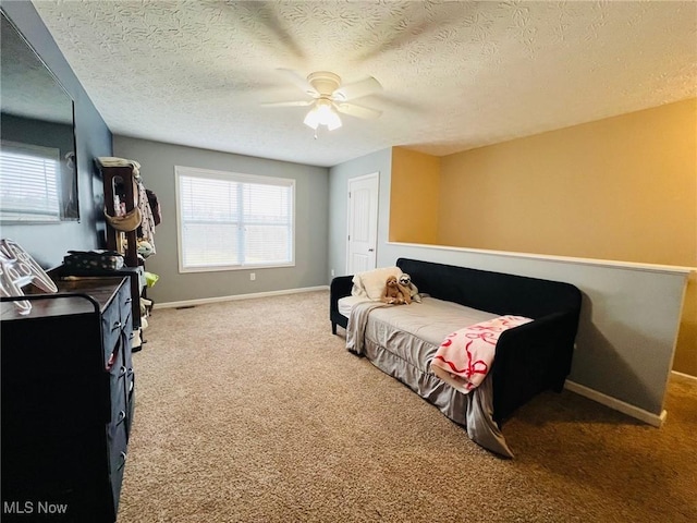 bedroom with ceiling fan, multiple windows, carpet, and a textured ceiling