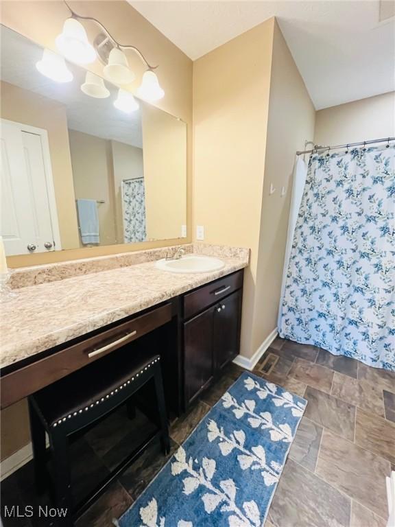 bathroom featuring vanity and curtained shower