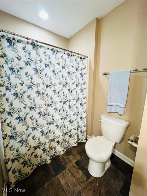 bathroom featuring toilet and a shower with shower curtain