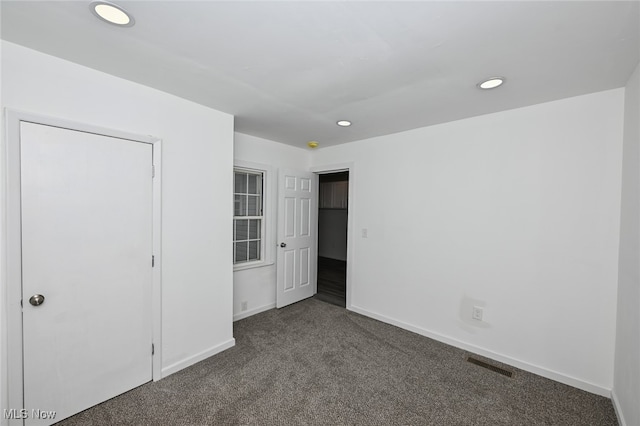 unfurnished bedroom featuring dark colored carpet