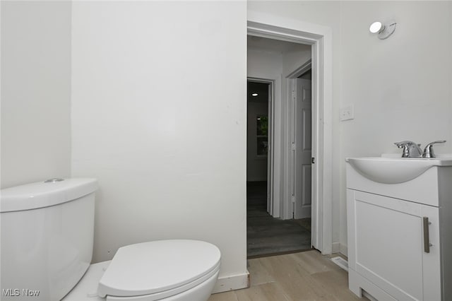 bathroom with vanity, toilet, and hardwood / wood-style flooring