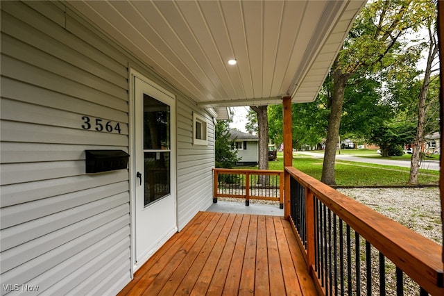 wooden deck featuring a lawn