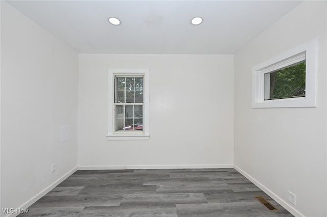 spare room featuring dark hardwood / wood-style flooring and a healthy amount of sunlight