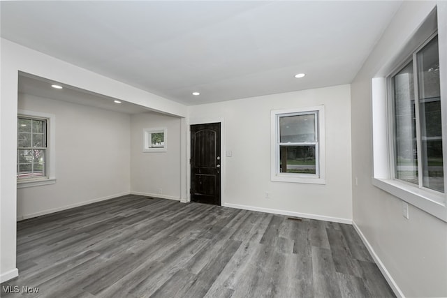 empty room with dark hardwood / wood-style flooring and a wealth of natural light