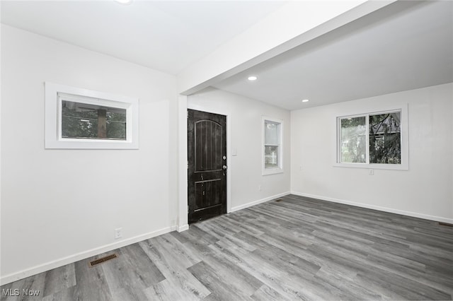 empty room with wood-type flooring and beam ceiling