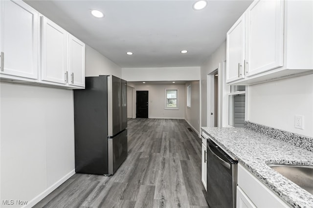 kitchen with light stone countertops, white cabinets, light hardwood / wood-style floors, and appliances with stainless steel finishes