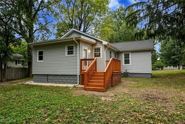 back of house with a lawn and central AC