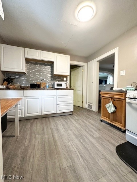 kitchen with white cabinets, white appliances, and light hardwood / wood-style floors