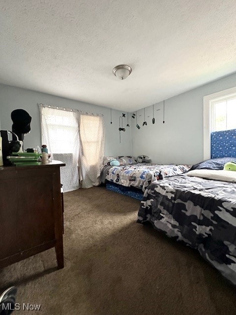 bedroom featuring a textured ceiling and carpet flooring