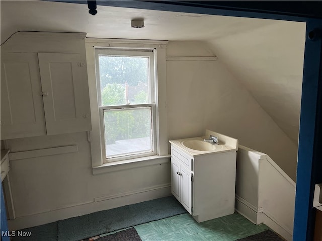 bathroom with vanity and lofted ceiling