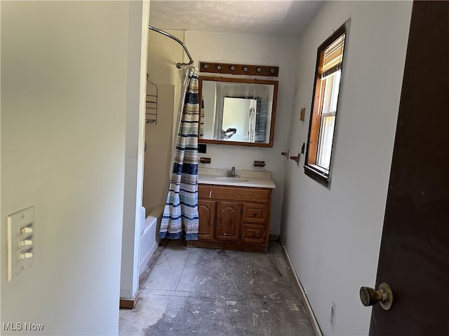 bathroom with a textured ceiling, shower / tub combo with curtain, and vanity