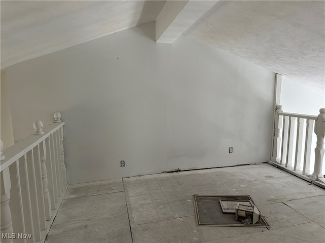 additional living space with vaulted ceiling with beams