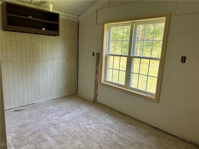 unfurnished room with lofted ceiling