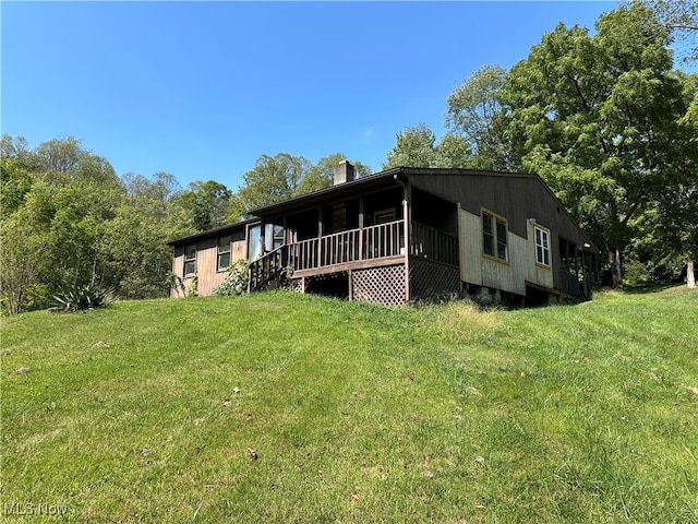 back of property with a lawn and a deck