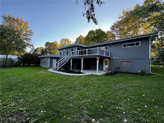 back of property with a deck and a yard