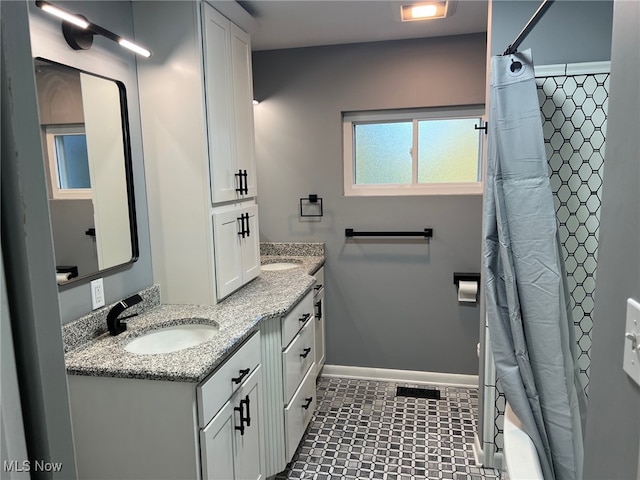 bathroom featuring vanity, shower / bath combo with shower curtain, and tile patterned flooring