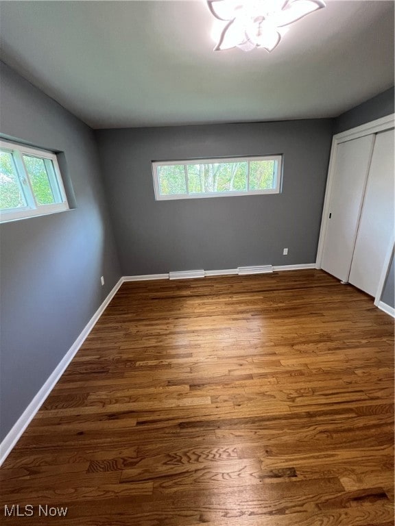 unfurnished bedroom with a closet and wood-type flooring